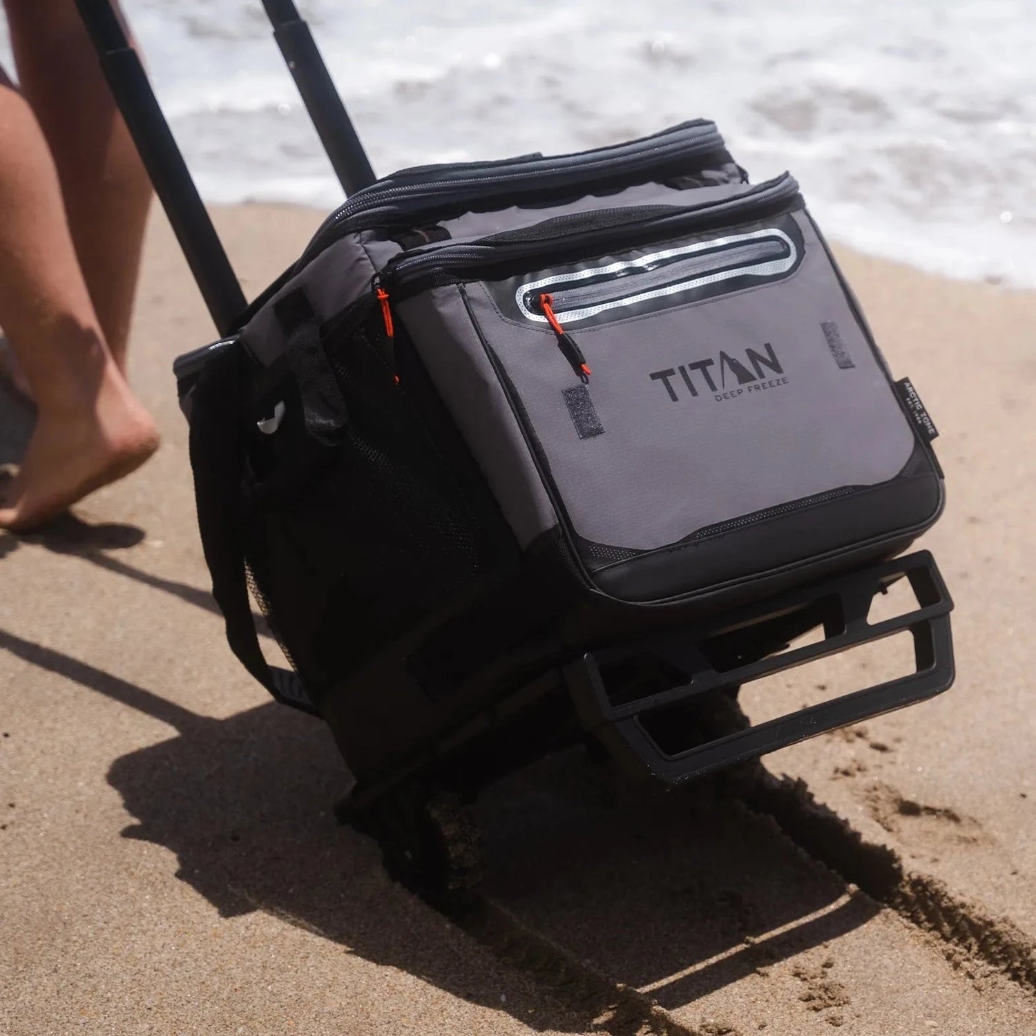 wheeled titan cooler on sandy beach near the water